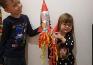 Chłopiec i dziewczynką trzymają wykonane przez siebie kolorowe rakiety